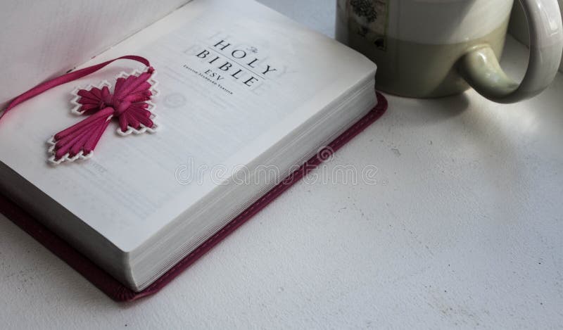 Une Sainte Bible ouverte avec une croix avec une tasse de café sur un fond blanc photographie stock libre de droits Une Sainte Bible ouverte avec une croix avec une tasse de café sur un fond blanc photographie stock libre de droits