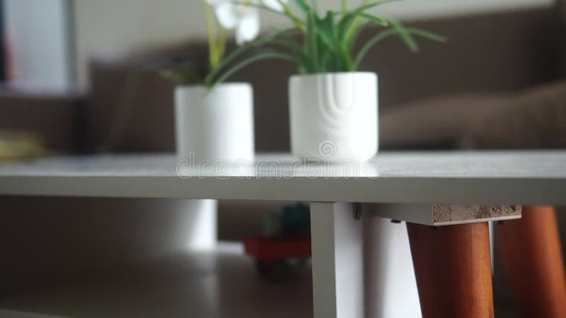 Une table basse blanche ornée d'un bouquet de fleurs banque de vidéos