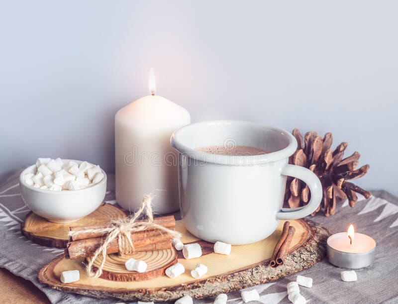 Une tasse de cacao chaud avec des guimauves et des bougies sur une table entourée par l'hiver ou le décor de Noël, plan rapproché images libres de droits Une tasse de cacao chaud avec des guimauves et des bougies sur une table entourée par l'hiver ou le décor de Noël, plan rapproché images libres de droits