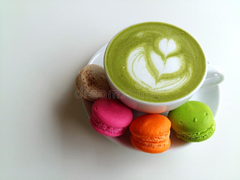 Une tasse de latte chaud de matcha si délicieux avec le macaron photo stock Une tasse de latte chaud de matcha si délicieux avec le macaron photo stock