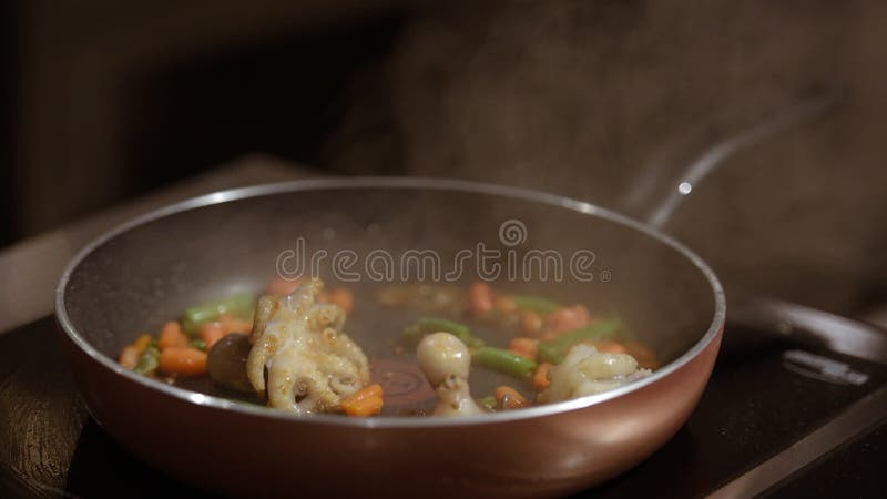 Une vidéo de clôture de la friture de poulpes avec des légumes sur une casserole avec de l'huile bouillante banque de vidéos