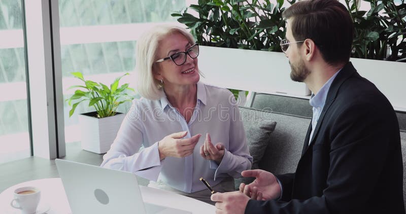 Une vieille femme d'affaires moyenne heureuse à débattre des idées de projet avec le partenaire. clips vidéos