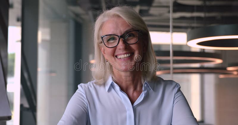 Une vieille femme d'affaires moyenne heureuse à regarder la vue parlante de webcam de caméra banque de vidéos