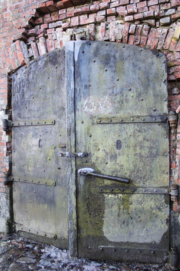 Une vieille porte en métal dans le mur de briques images stock Une vieille porte en métal dans le mur de briques images stock