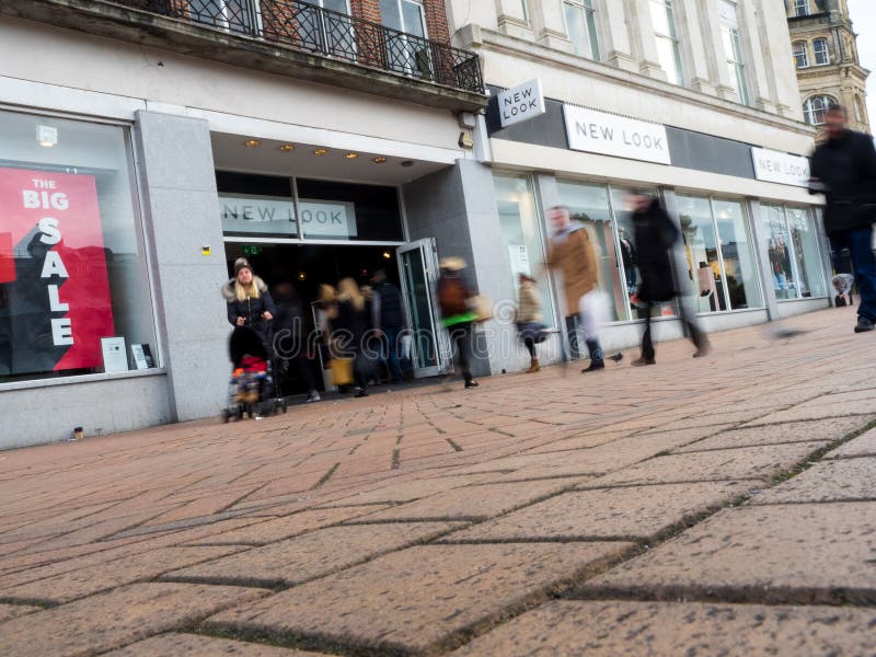Une vue de face d'un magasin de New Look avec des piétons brouillés dans le mouvement image stock Une vue de face d'un magasin de New Look avec des piétons brouillés dans le mouvement image stock