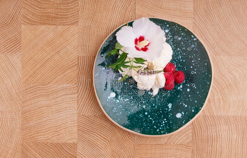 Une vue supérieure d'un plat complètement d'une crème glacée avec les framboises roses douces sur un fond en bois Casse-croûte or image stock Une vue supérieure d'un plat complètement d'une crème glacée avec les framboises roses douces sur un fond en bois Casse-croûte or image stock