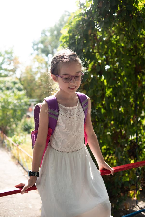 Fille Dans Un Chapeau Et Des Promenades Blanches De Robe Dans Le Jardin 