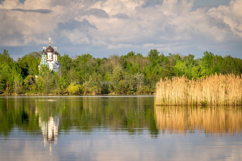 Une église orthodoxe blanche se reflétant dans l'eau photo stock Une église orthodoxe blanche se reflétant dans l'eau photo stock