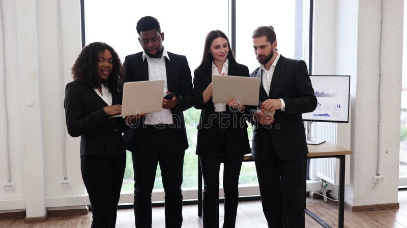 Une équipe d'affaires diversifiée avec des ordinateurs portables dans un bureau moderne banque de vidéos