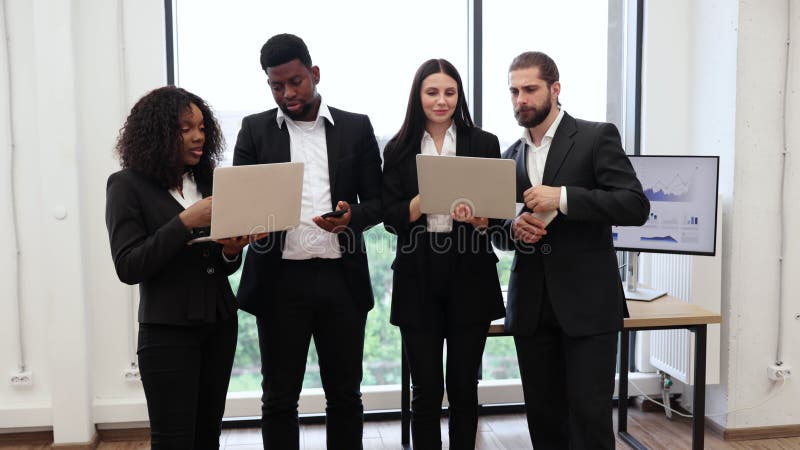 Une équipe d'affaires diversifiée avec des ordinateurs portables dans un bureau moderne banque de vidéos