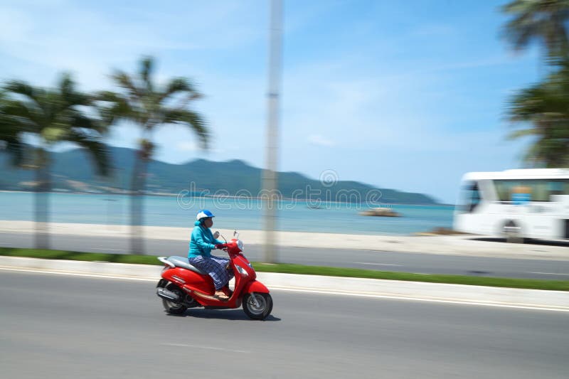 Unerkennbarer motobike Fahrer vor dem Strand nahe Nha Trang, Vietnam Gefangen genommen in der Bewegung, verwischt Mit a lizenzfreies stockbild Unerkennbarer motobike Fahrer vor dem Strand nahe Nha Trang, Vietnam Gefangen genommen in der Bewegung, verwischt Mit a lizenzfreies stockbild