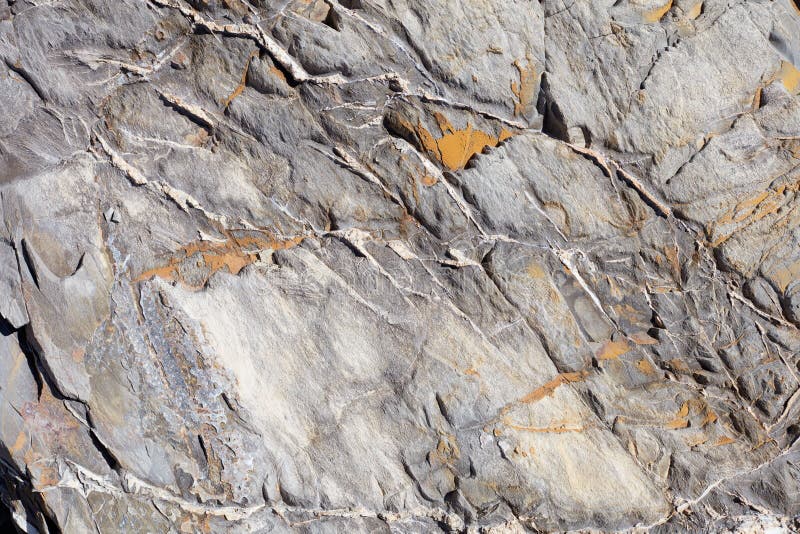 Uneven stone texture background with yellow lichen stock image