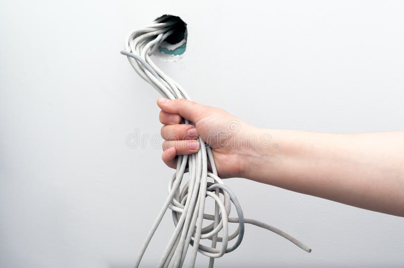 Unfinished electrical mains outlet socket with electrical wires in hand stock photography