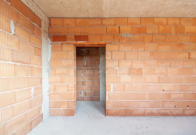 Unfinished room interior of building under construction. Brick red walls. New home