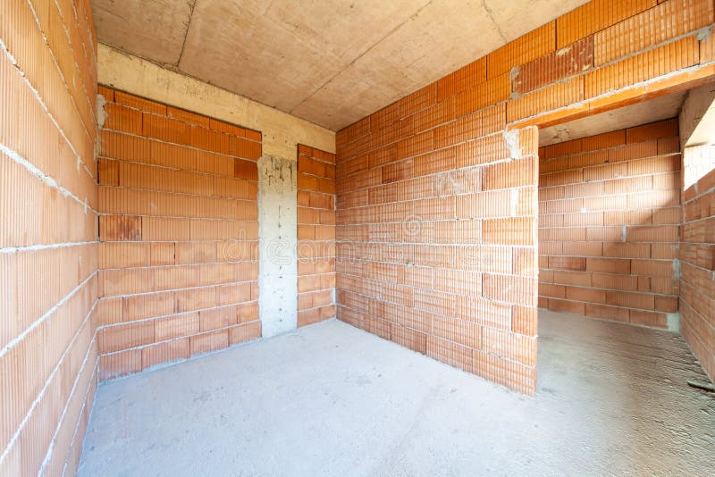 Unfinished room interior of building under construction. Brick red walls. New home