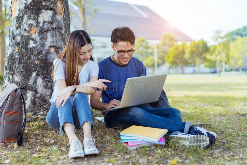 Ung asiat för studenter som använder tillsammans bärbar datordatoren royaltyfri fotografi Ung asiat för studenter som använder tillsammans bärbar datordatoren royaltyfri fotografi