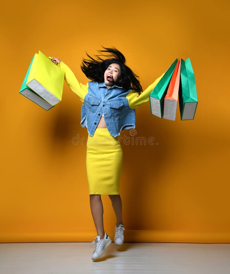 Ung asiatisk kvinna med shoppingp?sar p? f?rgbakgrund royaltyfria foton Ung asiatisk kvinna med shoppingp?sar p? f?rgbakgrund royaltyfria foton