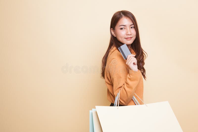 Ung asiatisk kvinna med shoppingpåsen och det tomma kortet