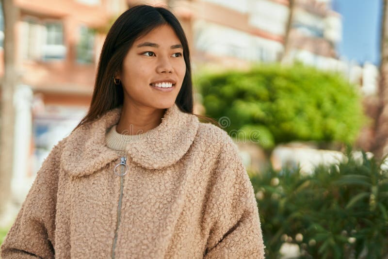 Ung asiatisk kvinna som log sig lycklig i staden royaltyfri foto