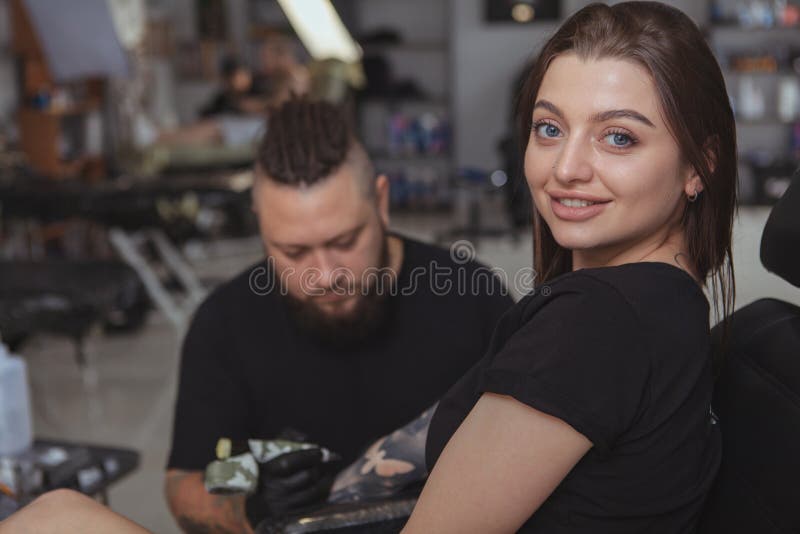 Ung attraktiv kvinna som får den nya tatueringen av den yrkesmässiga tattooisten arkivbilder Ung attraktiv kvinna som får den nya tatueringen av den yrkesmässiga tattooisten arkivbilder