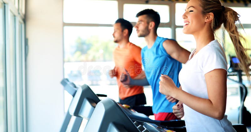 Ung attraktiv kvinna som gör cardio utbildning i idrottshall royaltyfria foton Ung attraktiv kvinna som gör cardio utbildning i idrottshall royaltyfria foton