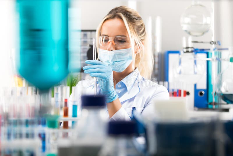 Ung attraktiv kvinnlig forskare som förbereder laboratoriumutrustning royaltyfri bild