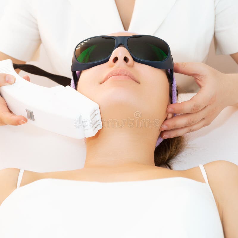 Young woman receiving epilation laser treatment in salon. Young woman receiving epilation laser treatment in salon