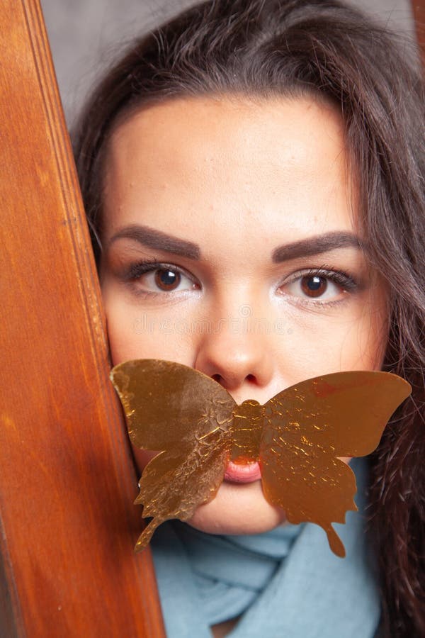 Ung blandtävlingskvinna leker med guldpapper Butterfly fotografering för bildbyråer