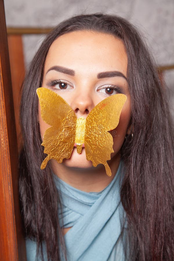 Ung blandtävlingskvinna leker med guldpapper Butterfly arkivbilder