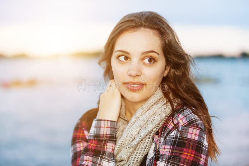 Candid portrait of young brunette woman at sunset looking away with copy space. Candid portrait of young brunette woman at sunset looking away with copy space