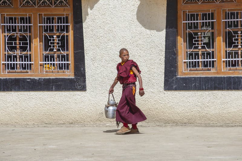 Ung buddistisk munk med färgade röda kläder under festivalen vid Lamayuru-klostret, Ladakh, Indien royaltyfri fotografi Ung buddistisk munk med färgade röda kläder under festivalen vid Lamayuru-klostret, Ladakh, Indien royaltyfri fotografi