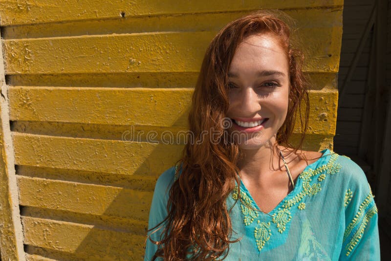 Ung Caucasian kvinna som ler och lutar mot strandkoja royaltyfri fotografi Ung Caucasian kvinna som ler och lutar mot strandkoja royaltyfri fotografi