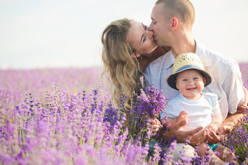 Ung familj i ett lavendelfält royaltyfri foto Ung familj i ett lavendelfält royaltyfri foto