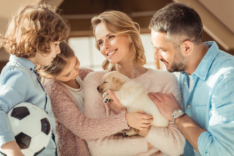 ung familj med den förtjusande labrador valpen framme av arkivbilder ung familj med den förtjusande labrador valpen framme av arkivbilder