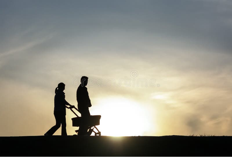 Ung familj som går på solnedgång fotografering för bildbyråer Ung familj som går på solnedgång fotografering för bildbyråer