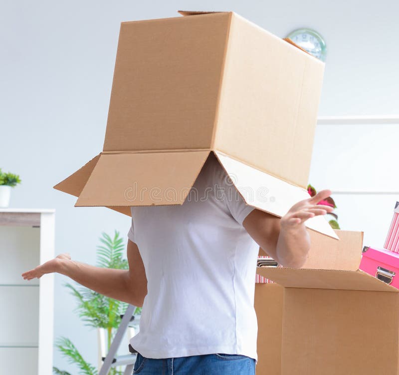 Ung familj som packar upp p? det nya huset med askar royaltyfri fotografi Ung familj som packar upp p? det nya huset med askar royaltyfri fotografi