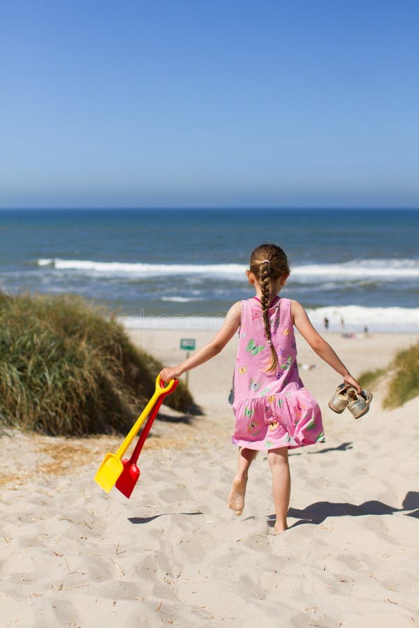 Ung flicka som går mot stranden