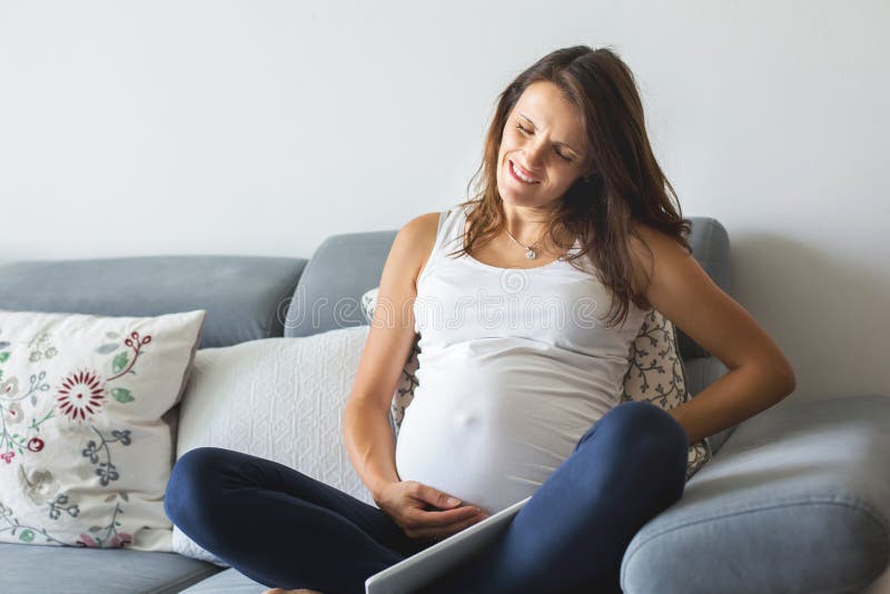 Ung gravid kvinna och att ha den smärtsamma sammandragningen som startar arbete arkivfoton Ung gravid kvinna och att ha den smärtsamma sammandragningen som startar arbete arkivfoton