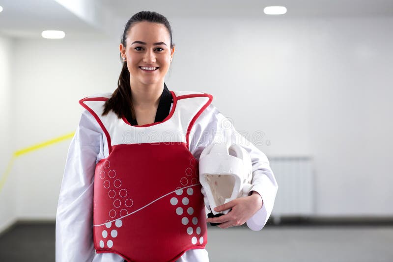 Ung gullig brunettflicka som bär det skyddande kampsportkugghjulet för Taekwondo fotografering för bildbyråer Ung gullig brunettflicka som bär det skyddande kampsportkugghjulet för Taekwondo fotografering för bildbyråer
