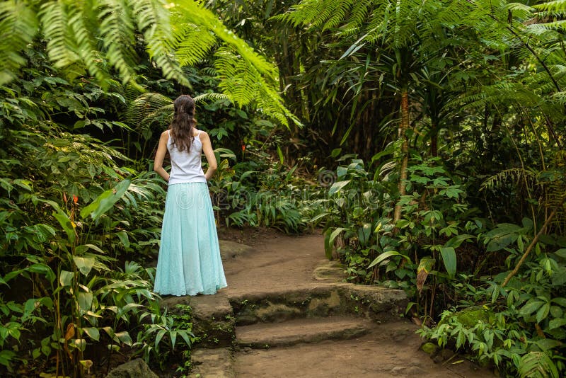 Ung handelsresandekvinna som går i den tropiska skogen, Ubud, Bali Sikt fr?n baksida royaltyfri bild Ung handelsresandekvinna som går i den tropiska skogen, Ubud, Bali Sikt fr?n baksida royaltyfri bild
