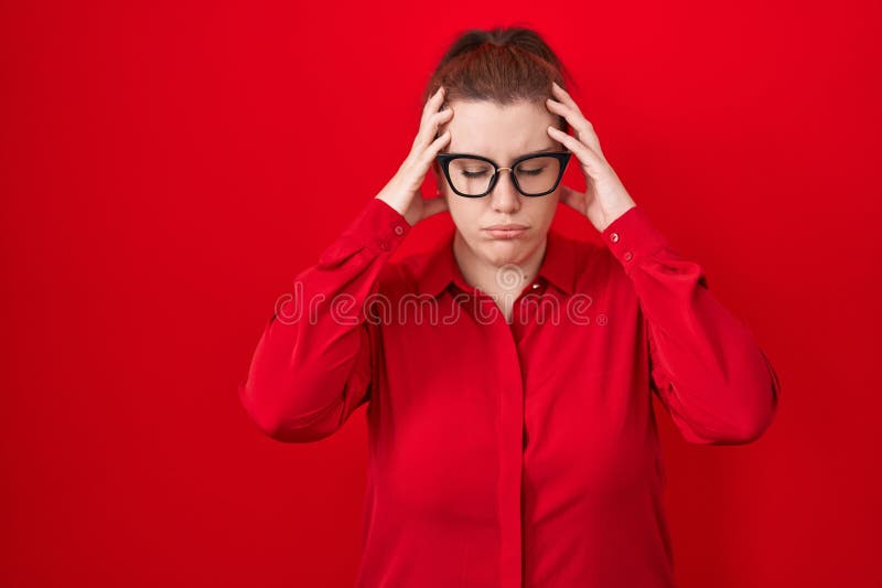 Ung historisk kvinna med rött hår som står över röd bakgrund med hand på huvudet för smärta i huvudet eftersom stress arkivfoto