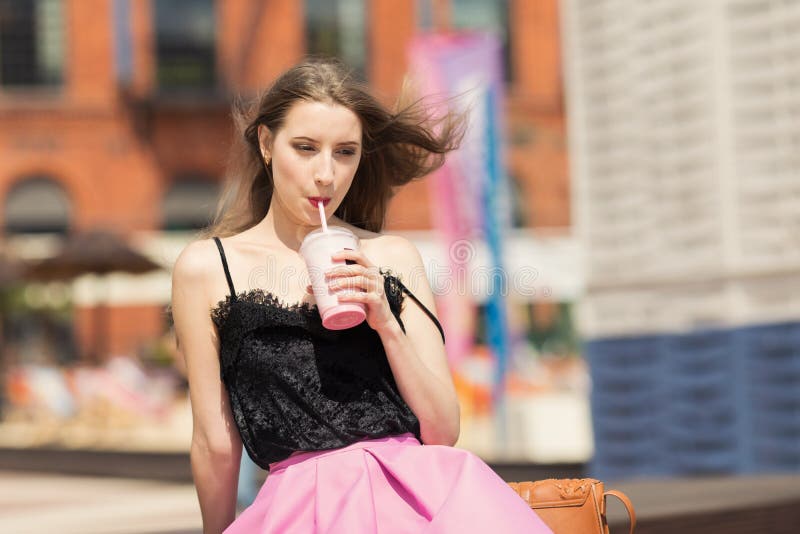 Ung härlig flicka med den långa smoothien för hårdrinkfrukt arkivbild Ung härlig flicka med den långa smoothien för hårdrinkfrukt arkivbild