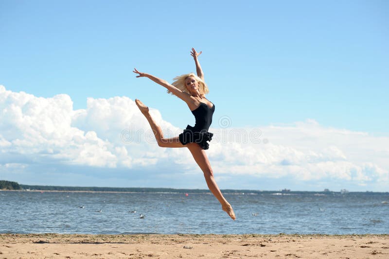 Ung härlig flicka som utomhus gör gymnastiska hopp arkivbilder Ung härlig flicka som utomhus gör gymnastiska hopp arkivbilder