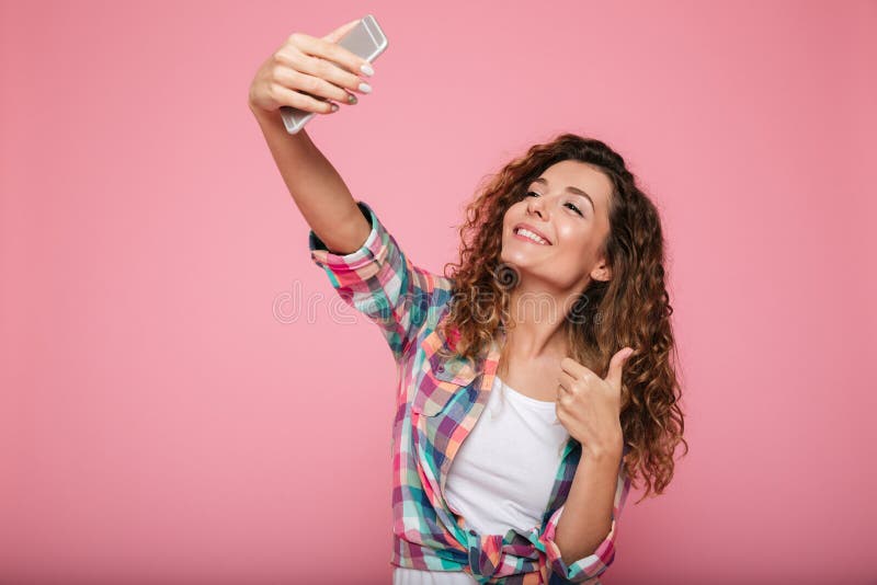 Ung härlig isolerad kvinnadanandeselfie på övre gest för smartphone och för visningtumme royaltyfri fotografi Ung härlig isolerad kvinnadanandeselfie på övre gest för smartphone och för visningtumme royaltyfri fotografi