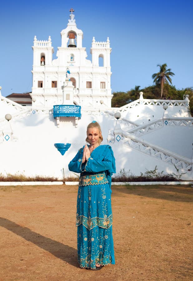 Ung härlig kvinna i nationell indierkläder nära den katolska templet, Goa arkivfoto Ung härlig kvinna i nationell indierkläder nära den katolska templet, Goa arkivfoto