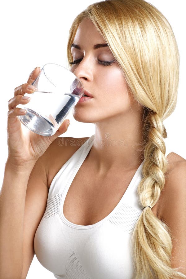 Young beautiful woman drinking a glass of water on white. Young beautiful woman drinking a glass of water on white