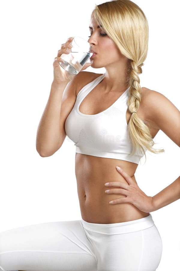 Young beautiful woman drinking a glass of water on white. Young beautiful woman drinking a glass of water on white
