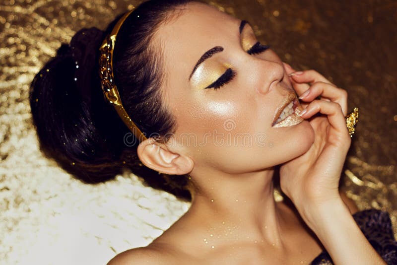 Ung härlig kvinnabrunett med den retro frisyren, beslag Guld- smink arkivbilder Ung härlig kvinnabrunett med den retro frisyren, beslag Guld- smink arkivbilder
