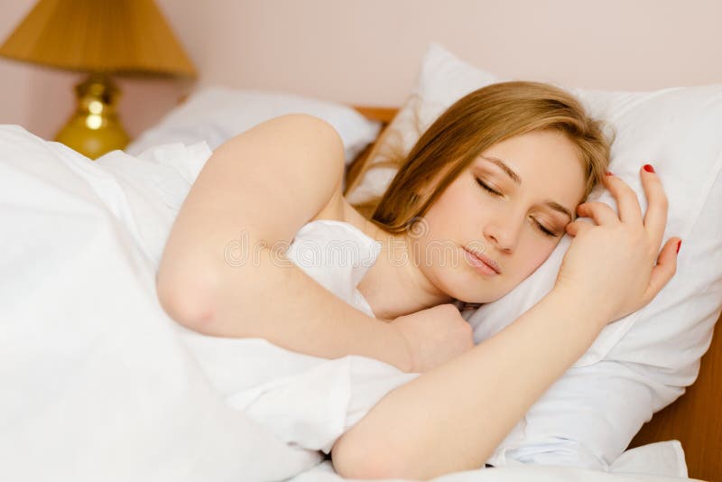 Ung härlig sova blond dam som ligger i säng arkivfoto Ung härlig sova blond dam som ligger i säng arkivfoto