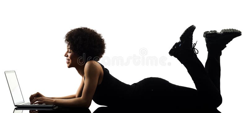 One mixed race african young teenager girl woman computer laptop in studio shadow silhouette isolated on white background. One mixed race african young teenager girl woman computer laptop in studio shadow silhouette isolated on white background